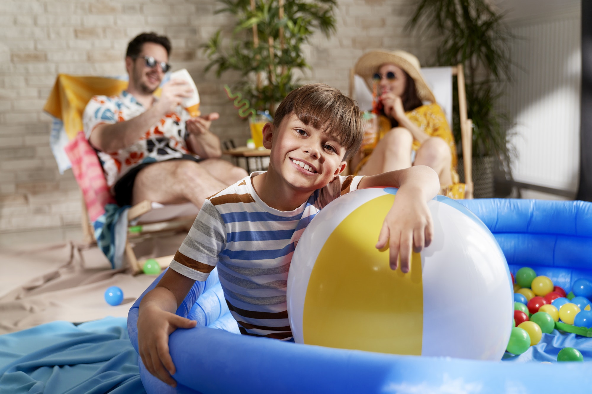 Portrait of relaxed boy in an inflatable ball pool at home